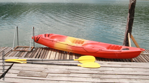 Fotografie Red kayak on wood floor