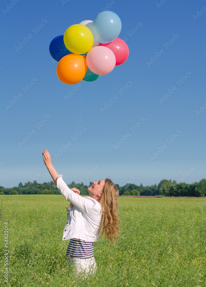 Young woman with colorful balloons in the field Young woman with colorful balloons in the field