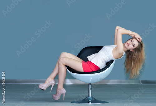 young girl on chair and touching her hair