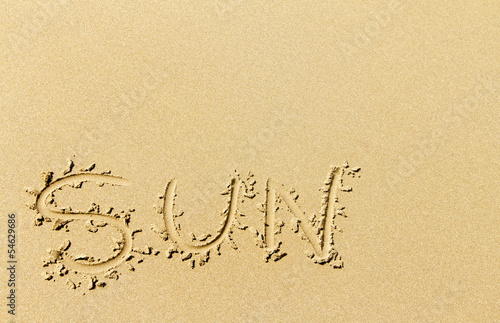 Word sun written on sandy beach