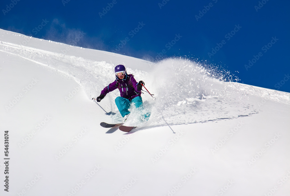 Woman Skier turns on a steep slope
