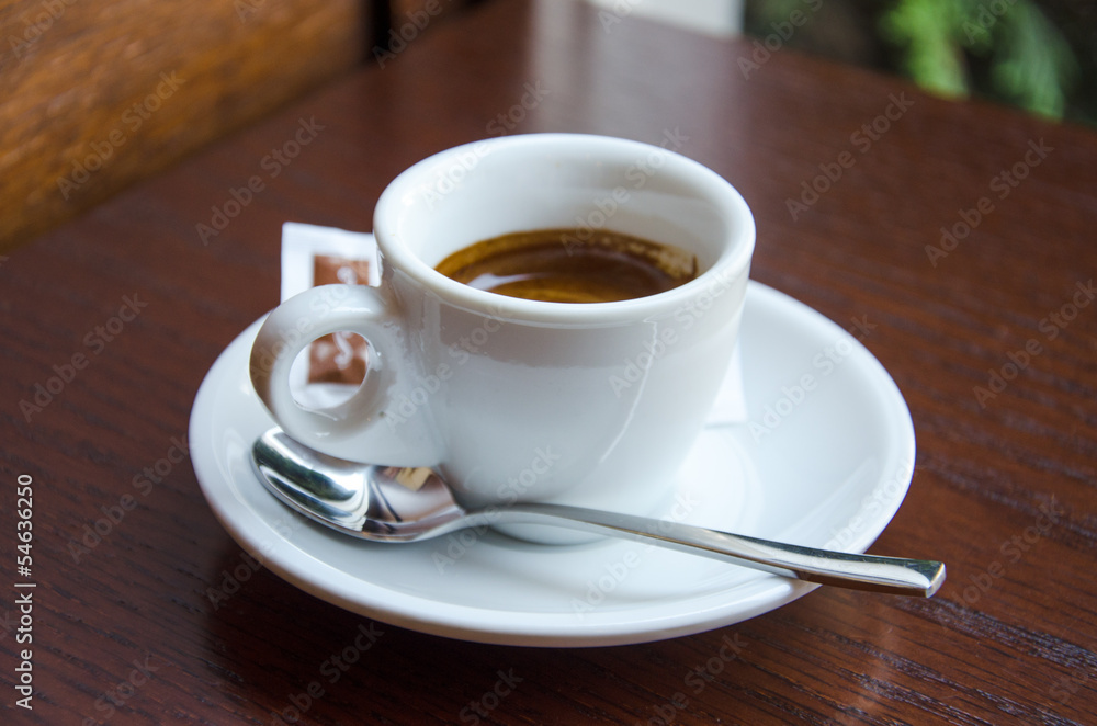 White espresso cup standing on the wooden table