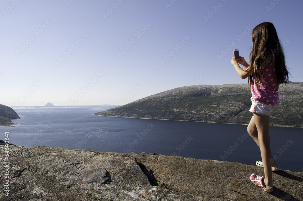 Girl photographing fjord in Norway