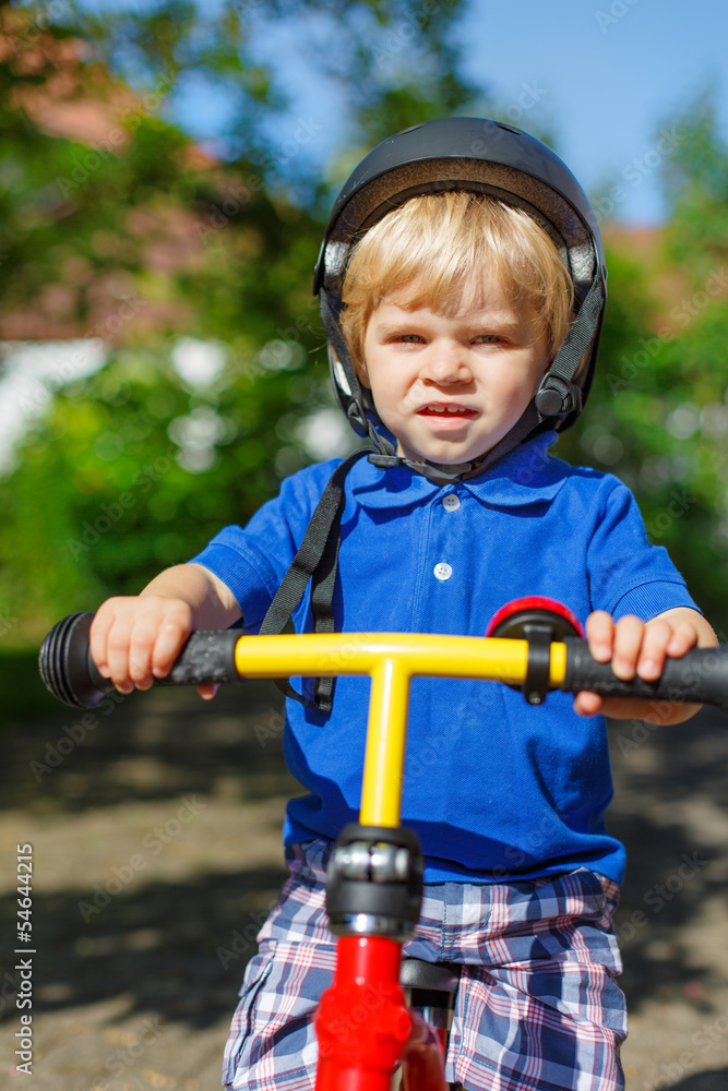 Little toddler boy riding on his bycicle in summer Little toddler boy riding on his bycicle in summer