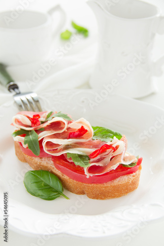 Bruschetta with prosciutto, tomato and basil.