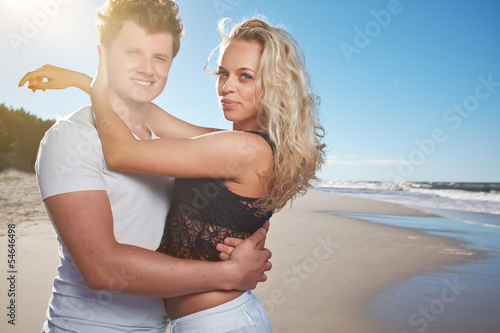 Smiling young couple at beautiful summer beach