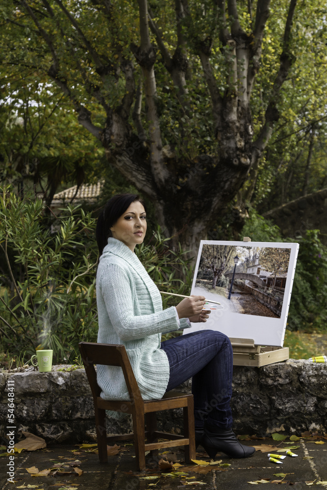 Fototapeta premium young woman painting on a park