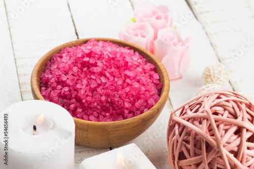 Sea salt in bowl with candle on wooden background