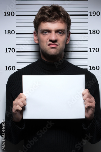 Busted burglar. Angry burglar holding a white poster while stand