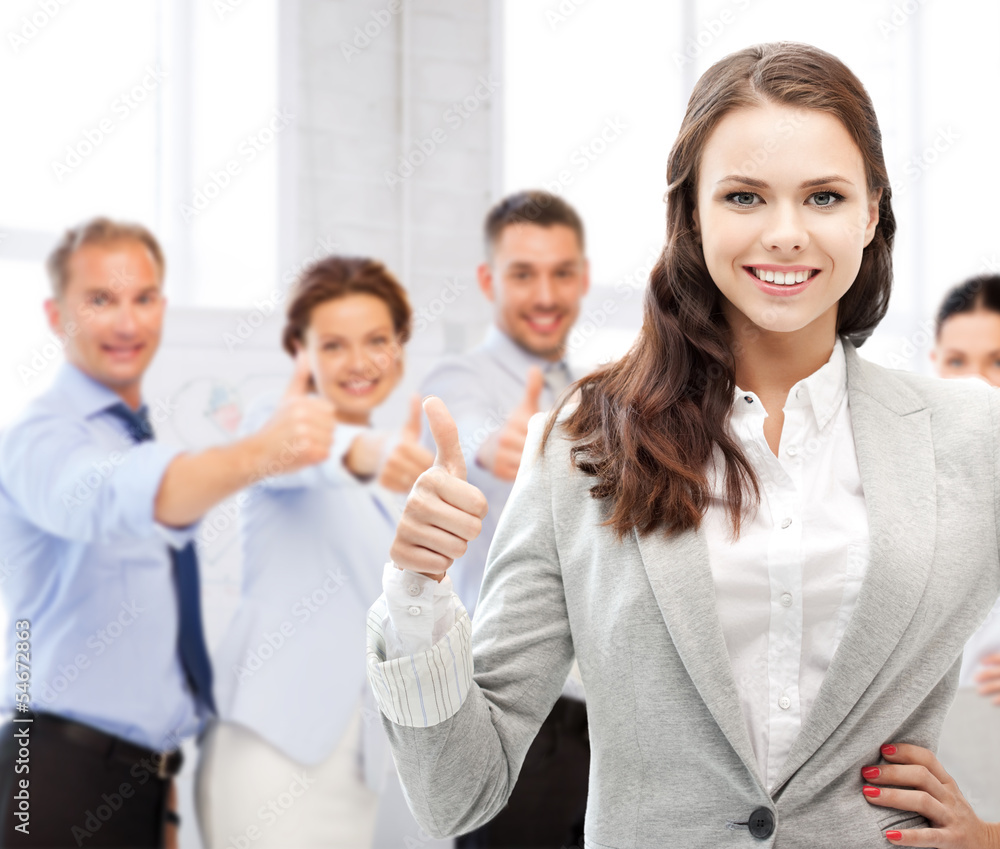 businesswoman showing thumbs up in office businesswoman showing thumbs up in office
