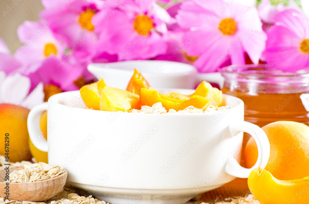 Apricot in the bowl, oatmeal, honey and milk jug