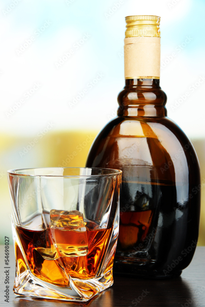Glass of liquor with bottle, on dark background Glass of liquor with bottle, on dark background