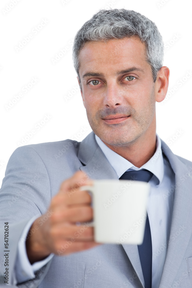 Handsome businessman offering cup of coffee Handsome businessman offering cup of coffee