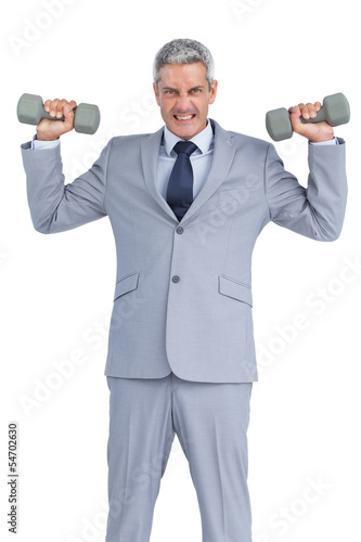 Strong businessman lifting dumbbells