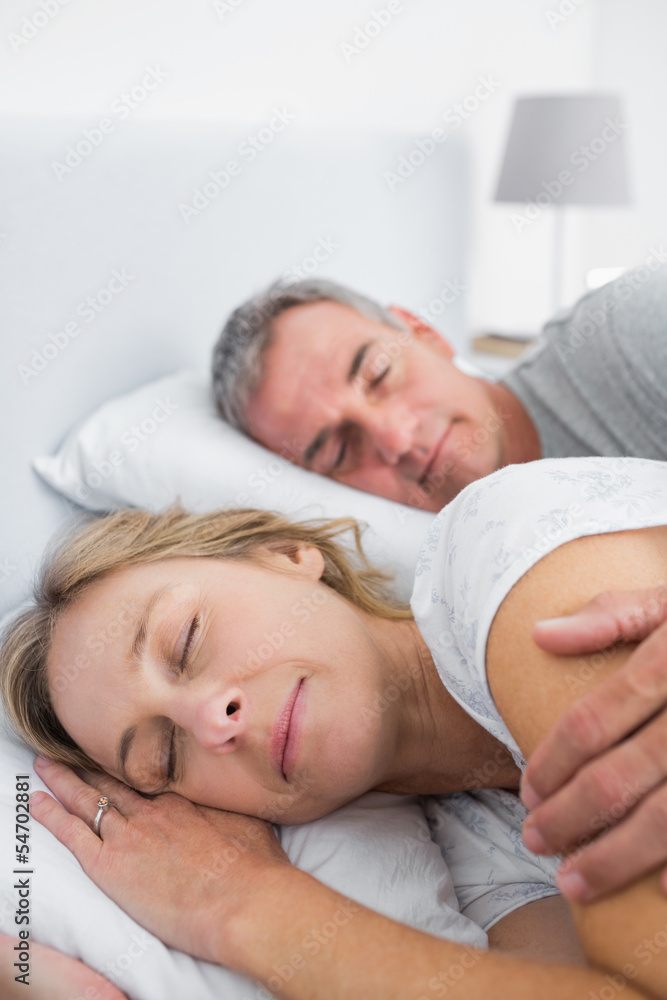 Peaceful couple sleeping and spooning in bed Peaceful couple sleeping and spooning in bed
