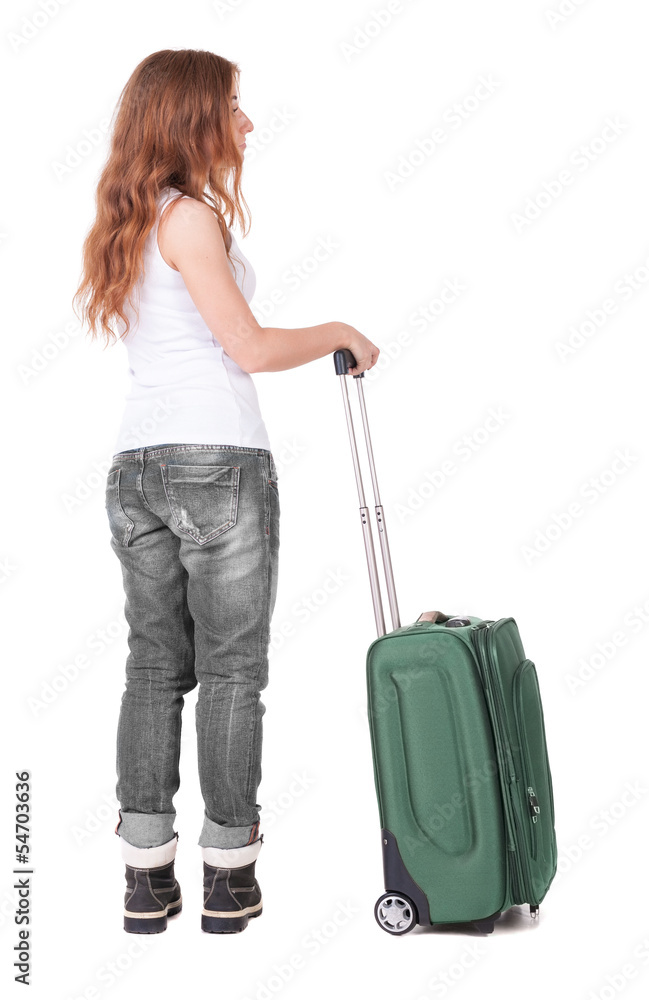 Back view of stylishly dressed woman with suitcase looking up Back view of stylishly dressed woman with suitcase looking up