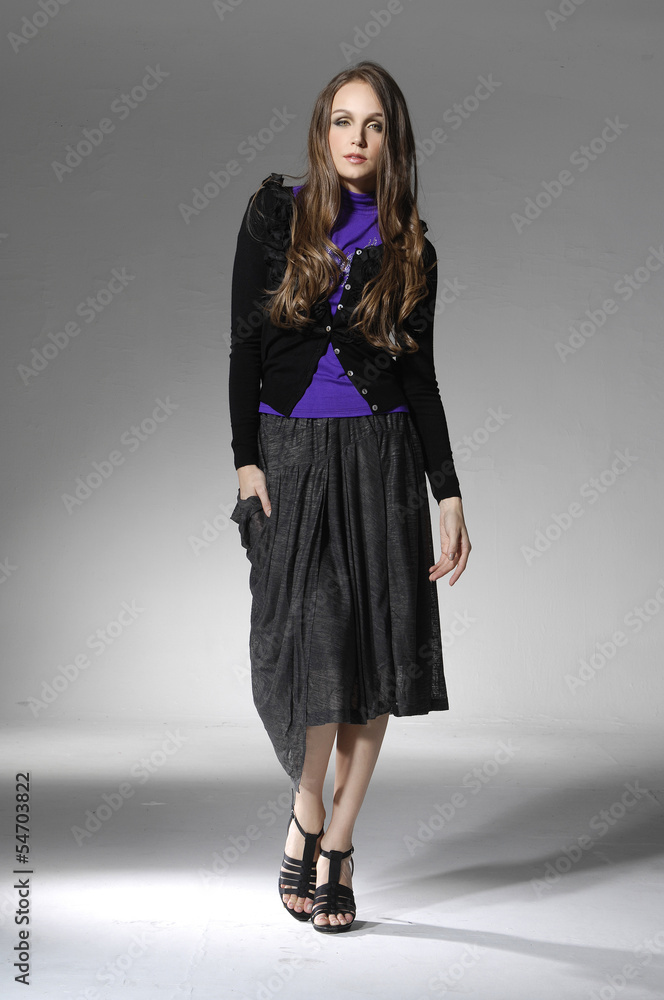 attractive young girl standing against gray background attractive young girl standing against gray background