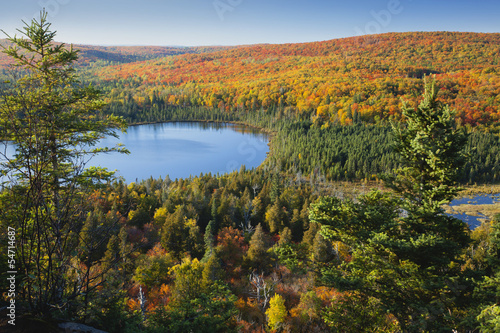 Small blue lake amid hills in autumn color