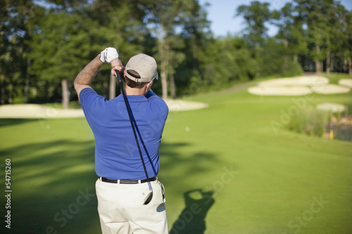 Golfer hitting onto defocused green