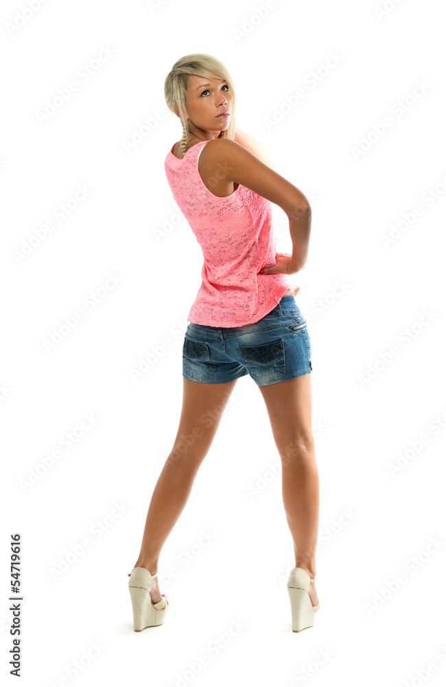 Sexy girl in denim shorts looks back at the studio. View from th Sexy girl in denim shorts looks back at the studio. View from th