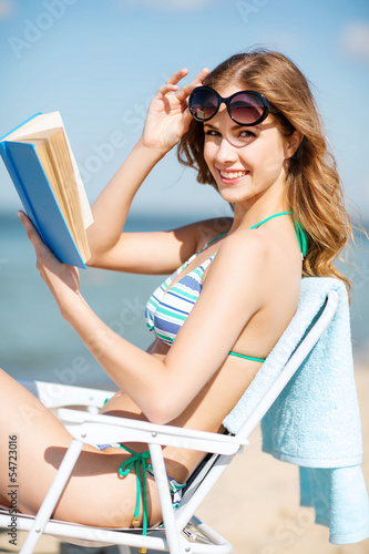 girl reading book on the beach chair