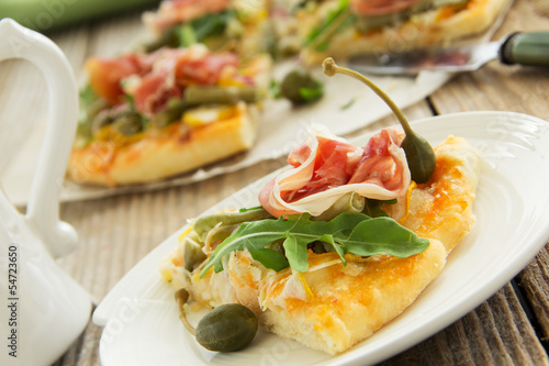 Pizza with arugula and prosciutto.