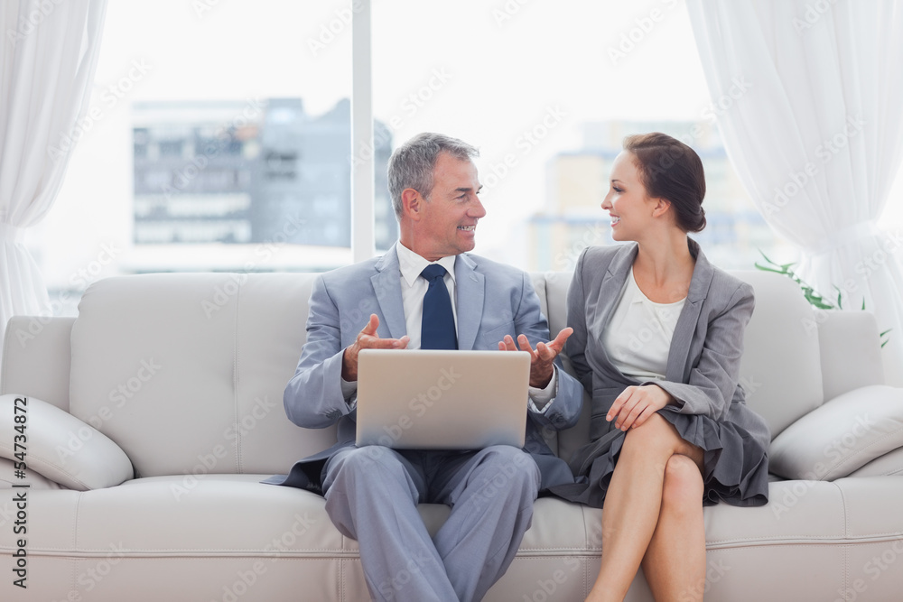 Workmates working together sitting on sofa Workmates working together sitting on sofa