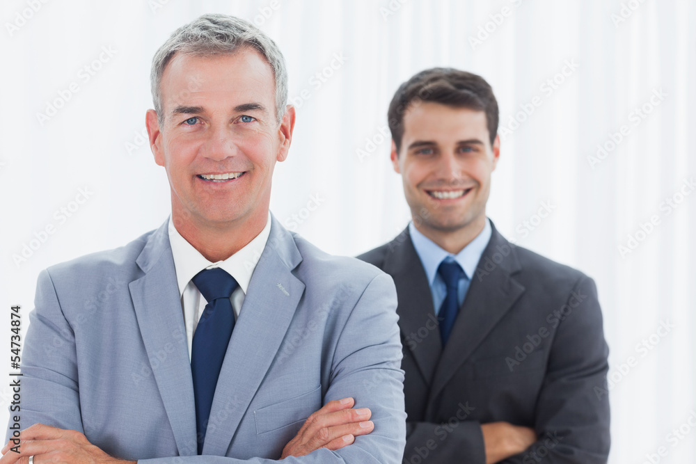 Smiling businessmen posing looking at camera Smiling businessmen posing looking at camera