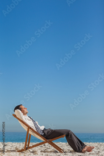 Fototapeta Naklejka Na Ścianę i Meble -  Young businessman resting on his deck chair