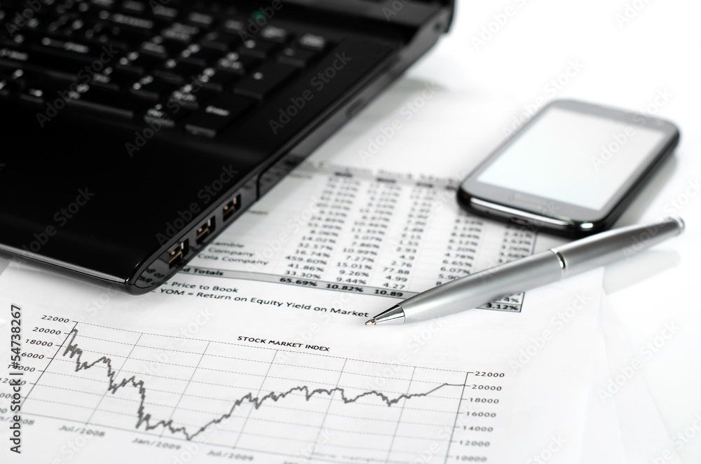 business concept with charts, smart phone, laptop and silver pen business concept with charts, smart phone, laptop and silver pen