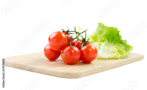 cherry tomatoes and lettuce on a cutting board