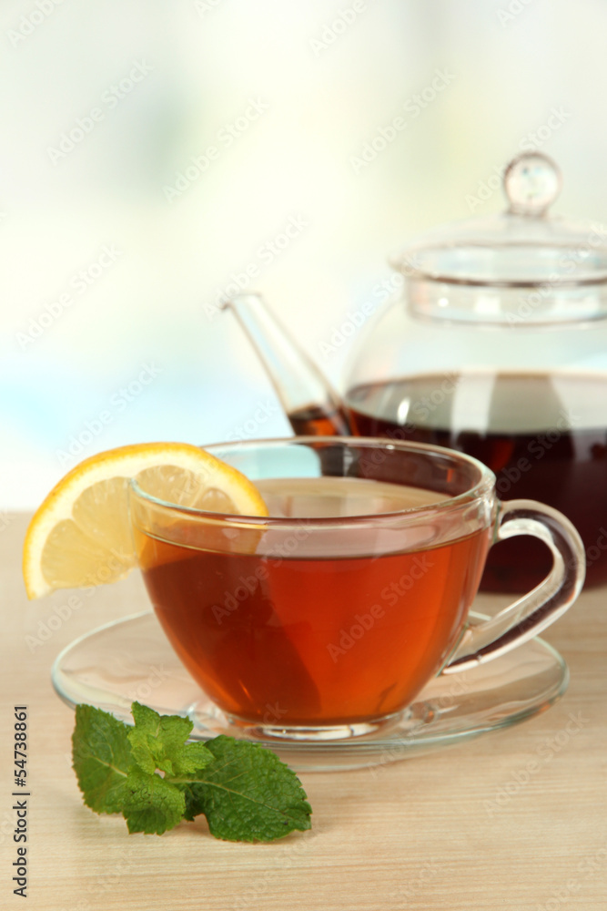 Cup of tea with lemon on table on light background Cup of tea with lemon on table on light background