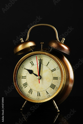 Old alarm clock isolated on black