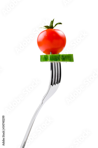 fresh tomato and a slice of cucumber on a fork