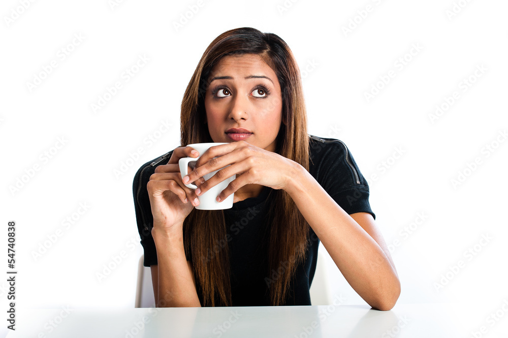 Attractive young asian indian woman enjoying a drink in a mug Attractive young asian indian woman enjoying a drink in a mug