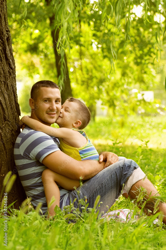 Fototapeta premium Father and son playing on green field