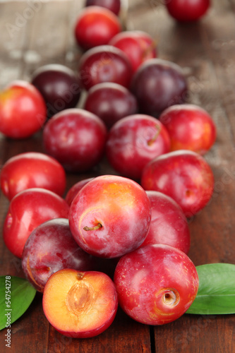 Ripe plums on wooden table close-up