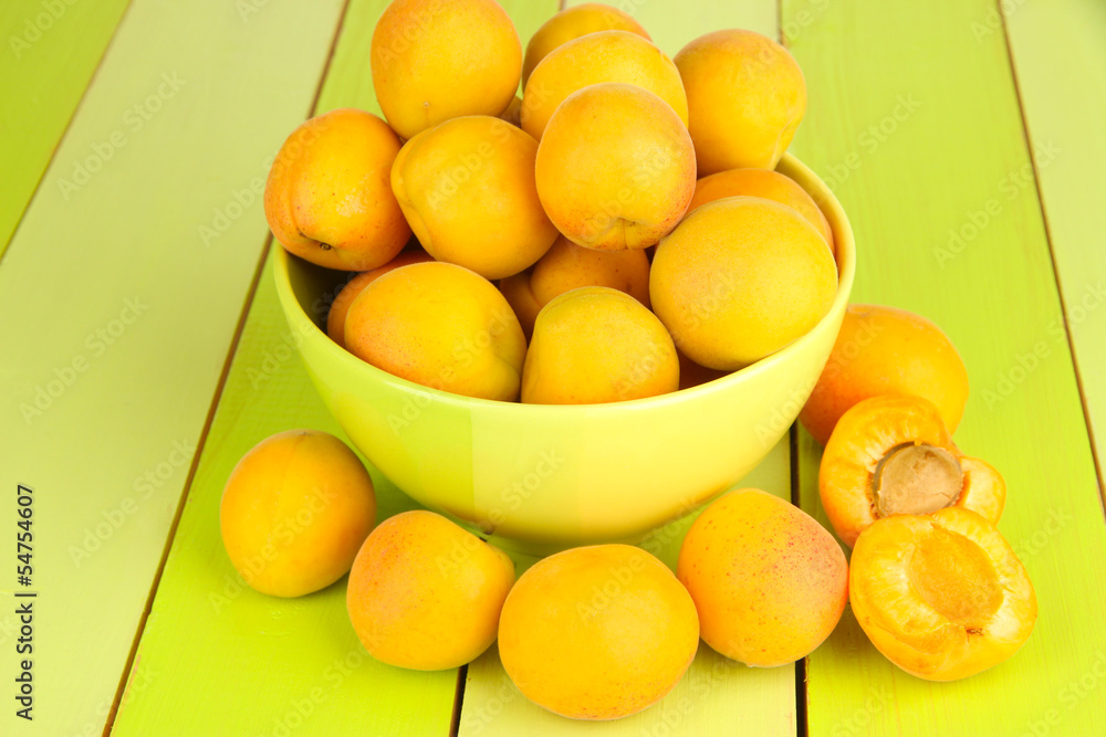 Fresh natural apricot in bowl on green wooden table Fresh natural apricot in bowl on green wooden table