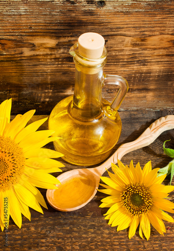 still life with vegetable oil in a bottle and sunflowers