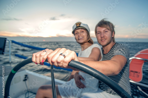 Young couple navigating on a yacht © Alex Shadrin