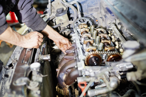 Obraz na plátne Hands of mechanic servicing car engine