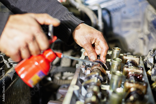 Valokuva Hands of mechanic, who lubricates car engine
