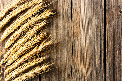 Rye spikelets on wooden background