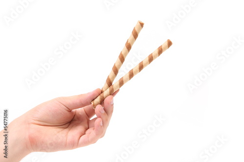 Hand holds striped chocolate wafer rolls