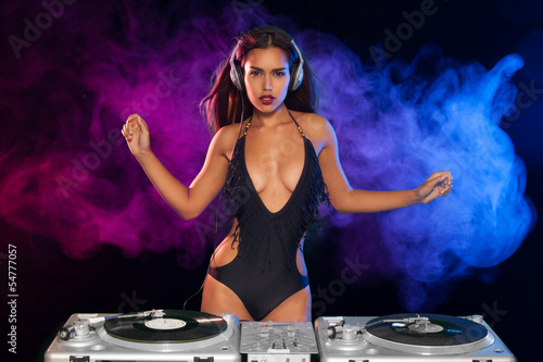 Beautiful DJ girl on decks on the party,