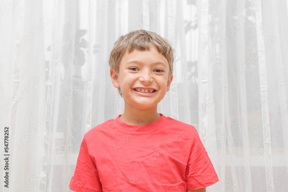 Blonde boy in a red shirt indoors Blonde boy in a red shirt indoors