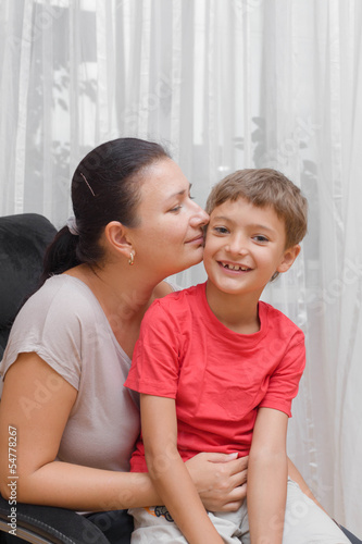 Happy mother embracing and kissing her son