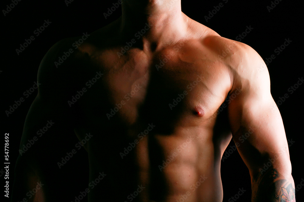 Healthy muscular young man. Isolated on black background