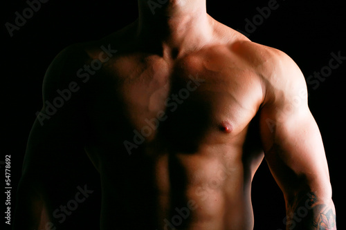 Healthy muscular young man. Isolated on black background