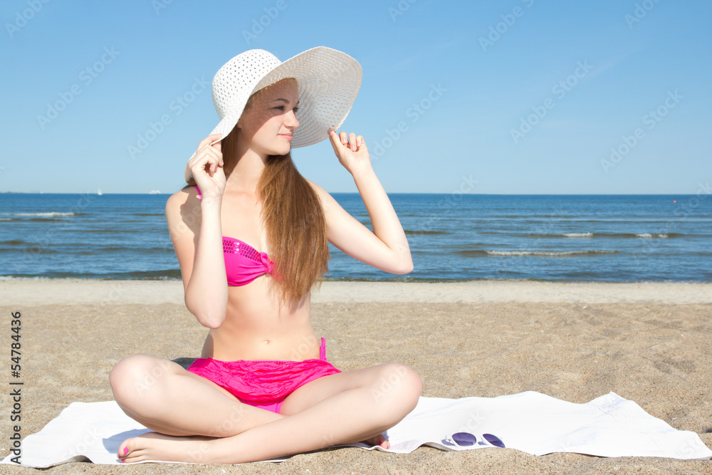 attractive woman in pink swimsuit sitting on the beach attractive woman in pink swimsuit sitting on the beach